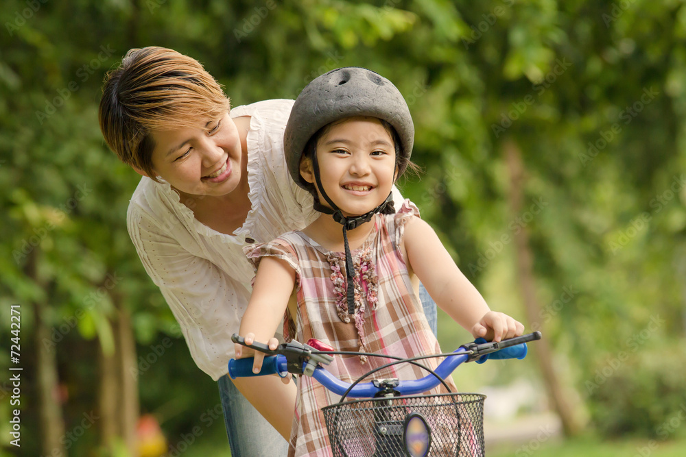 亚洲小孩和妈妈练习骑自行车