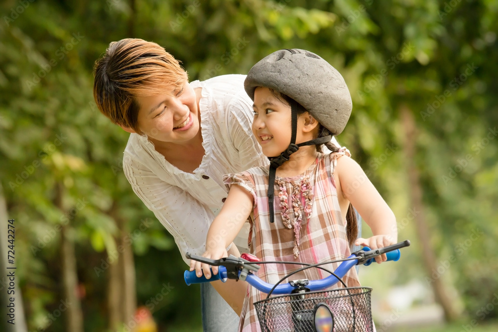 亚洲小孩和妈妈练习骑自行车