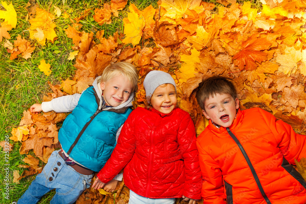 快乐的孩子们一起躺在秋叶上