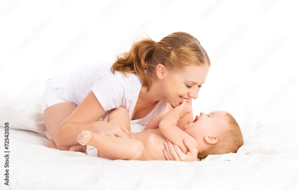 快乐的家庭妈妈和宝宝在床上玩得很开心，笑得很开心