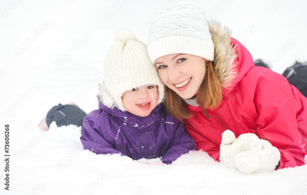 幸福的家庭妈妈和宝贝女儿在冬雪中玩耍