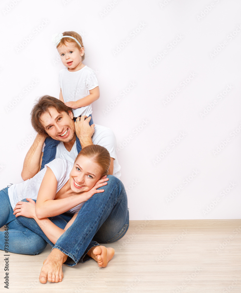 幸福的一家人在公寓空墙附近的地板上