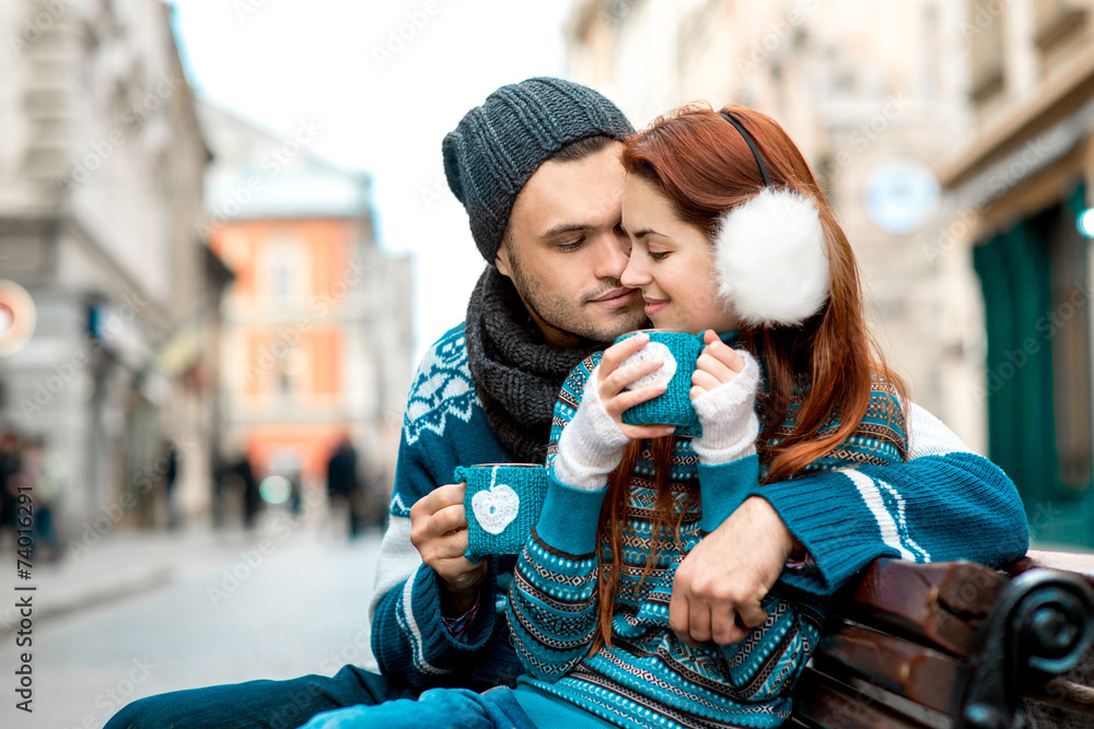 年轻夫妇在外面喝咖啡的冬天