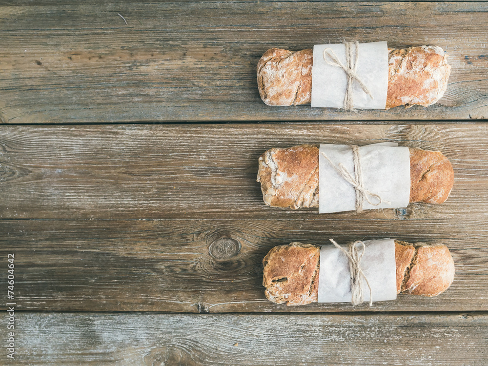 新鲜出炉的乡村面包（法棍面包），镶嵌在粗糙的木头上