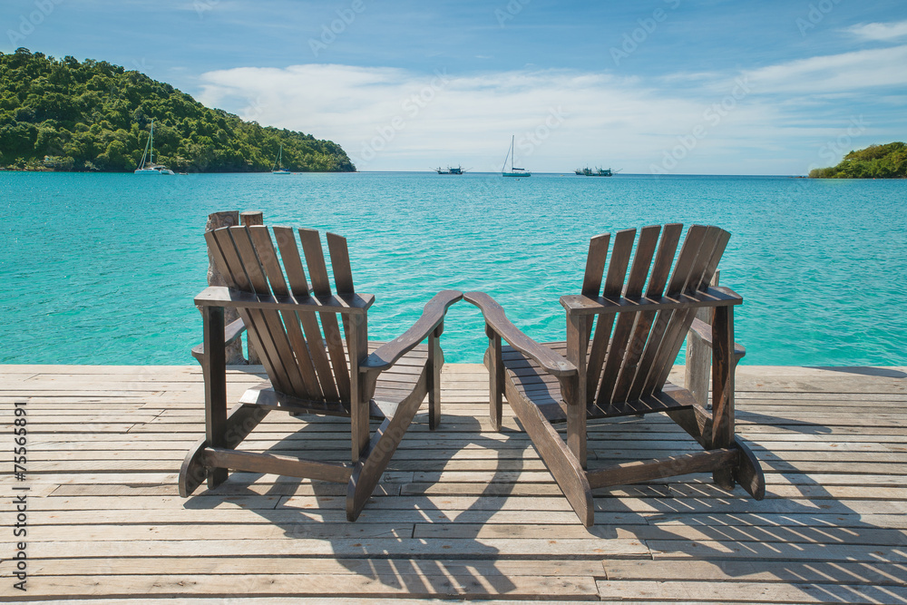 海景木地板上摆放的两把沙滩椅