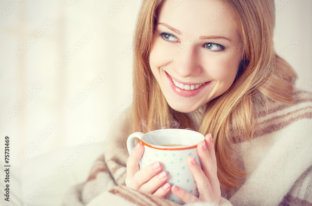 幸福的女人在毯子和咖啡下