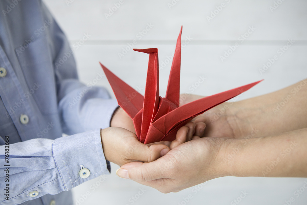 母亲和孩子的手，放着纸鹤