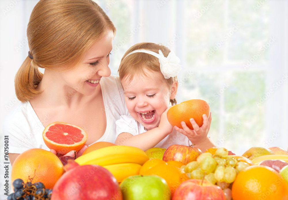 幸福的家庭母亲和女儿吃健康的食物，水果
