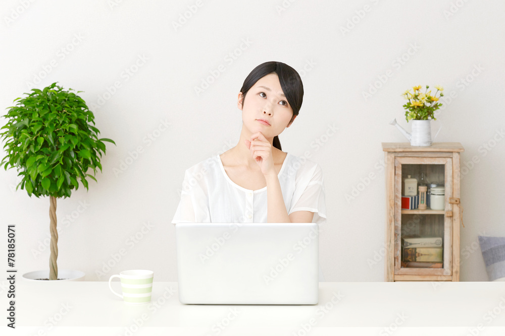 パソコンの前で考える女性