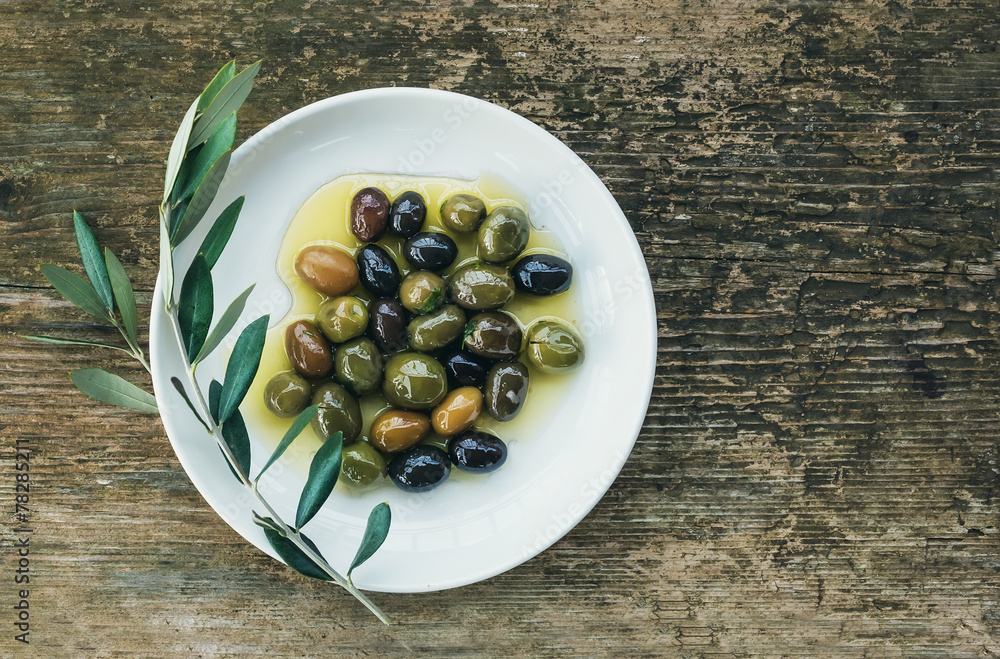 一盘橄榄油中的地中海橄榄，配一根橄榄枝