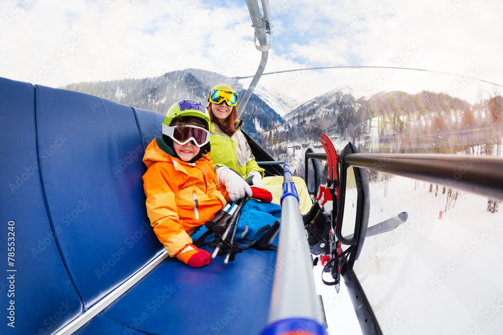 滑雪缆车上的小男孩和妈妈