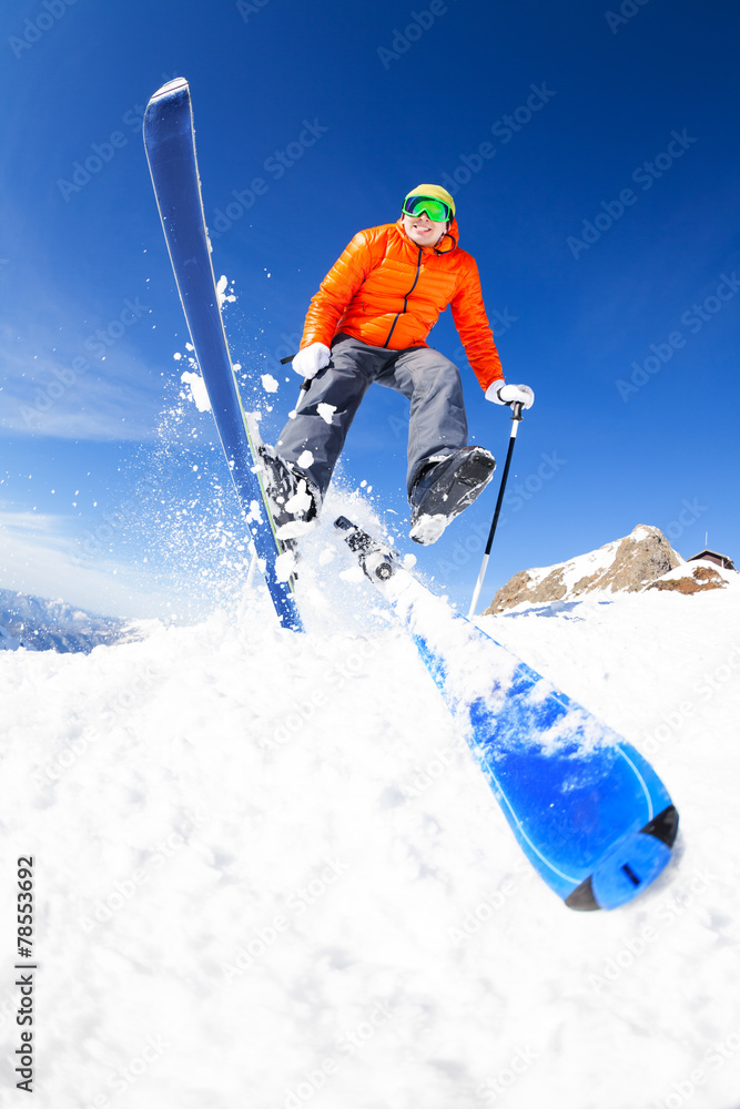 年轻人在滑雪时跳跃，从下面看