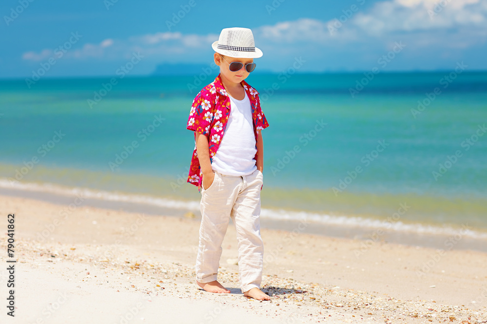 可爱时尚的男孩漫步夏日海滩