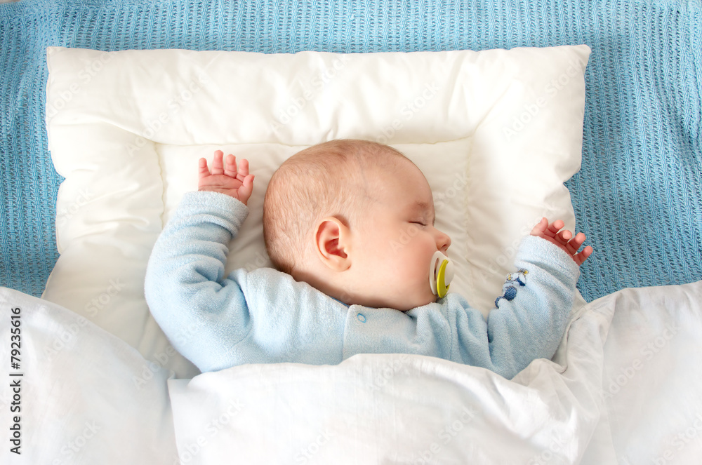 四个月大的婴儿睡在蓝色毯子上