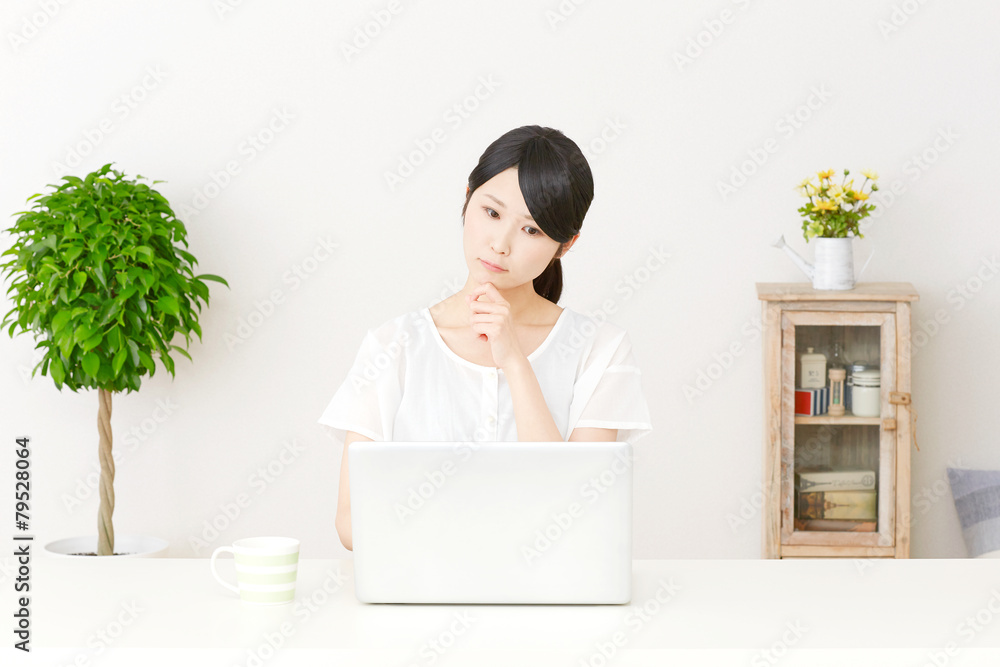 パソコンの前で考える女性