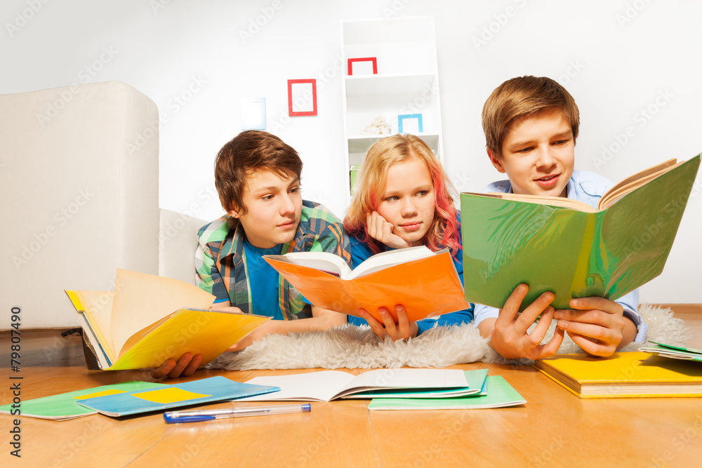 三个快乐的青少年孩子读书做作业