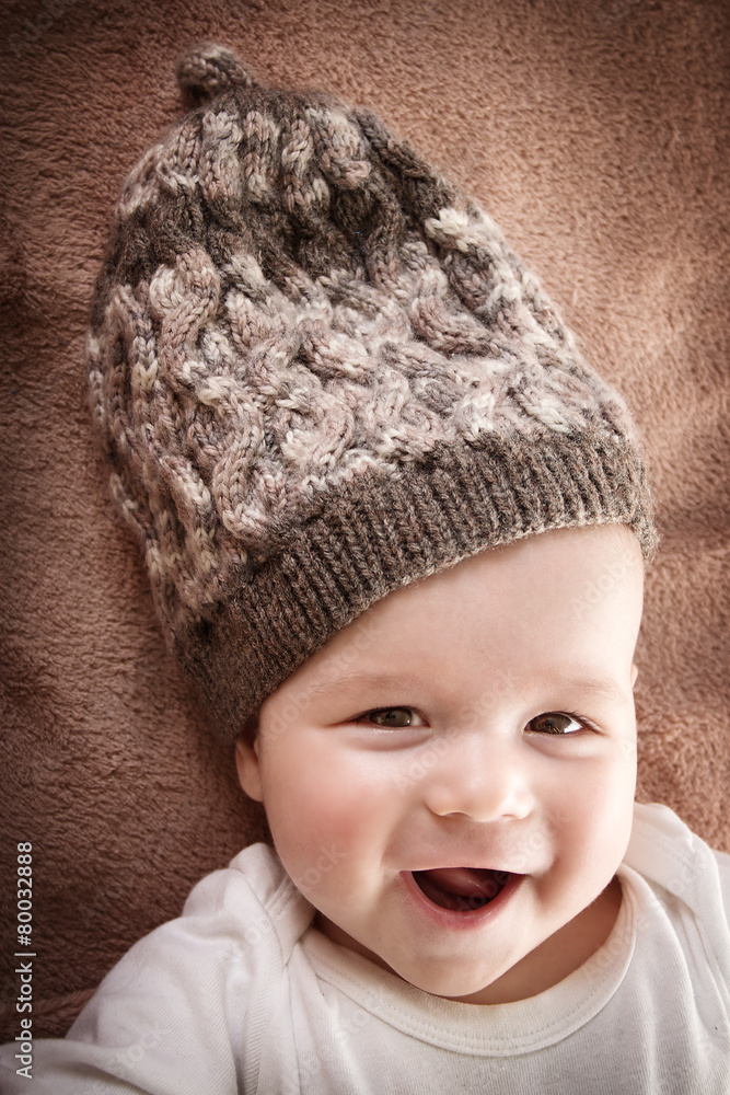 棕色毛皮背景戴帽子的婴儿