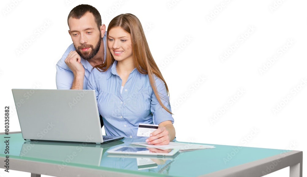 购买。快乐夫妇使用笔记本电脑在线购物的肖像