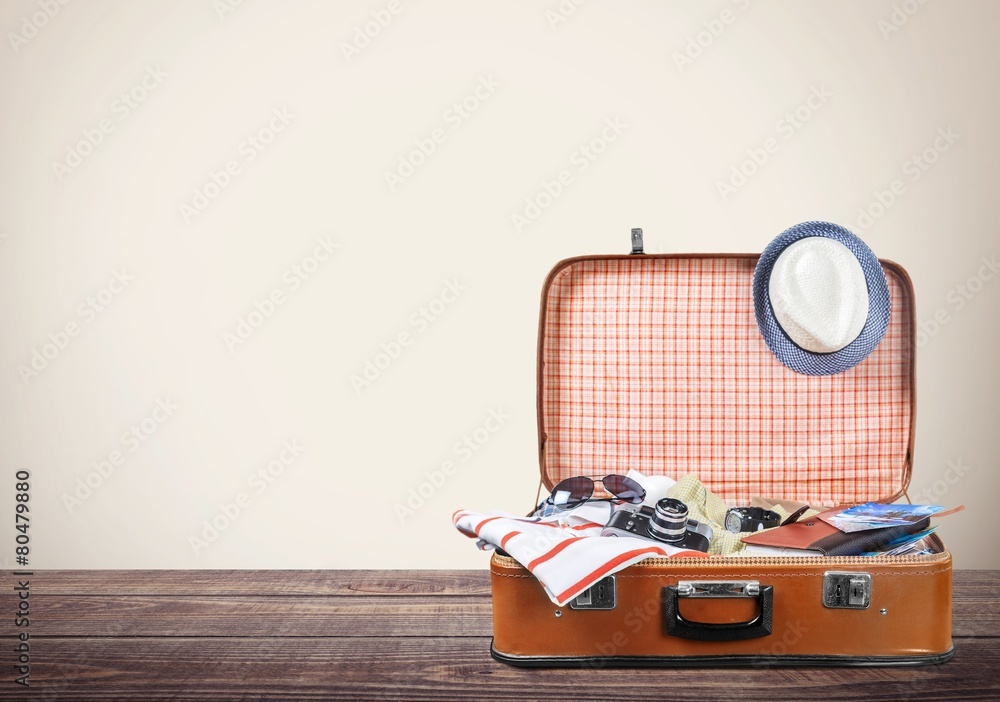 旅行。复古的旅游行李，五颜六色的衣服和