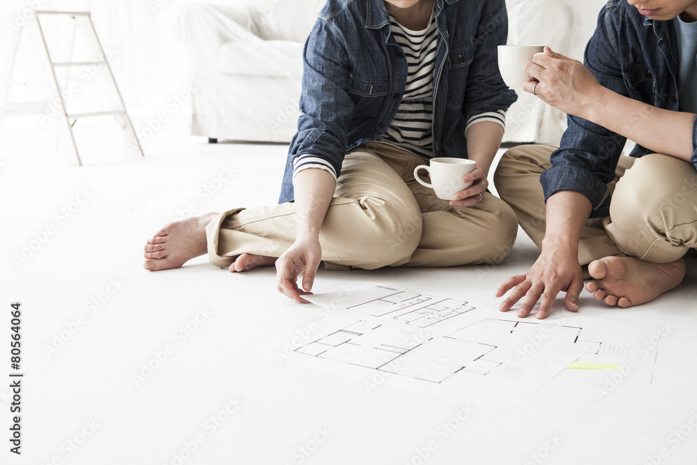 Couple drinking coffee while watching the floor plan