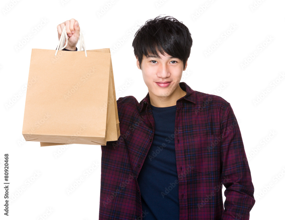 快乐的亚洲男人拿着购物袋购物