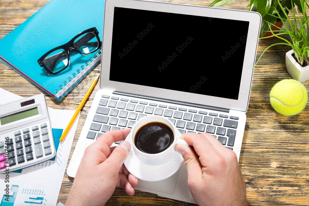 笔记本电脑。带咖啡的笔记本电脑上的在线金融商业新闻