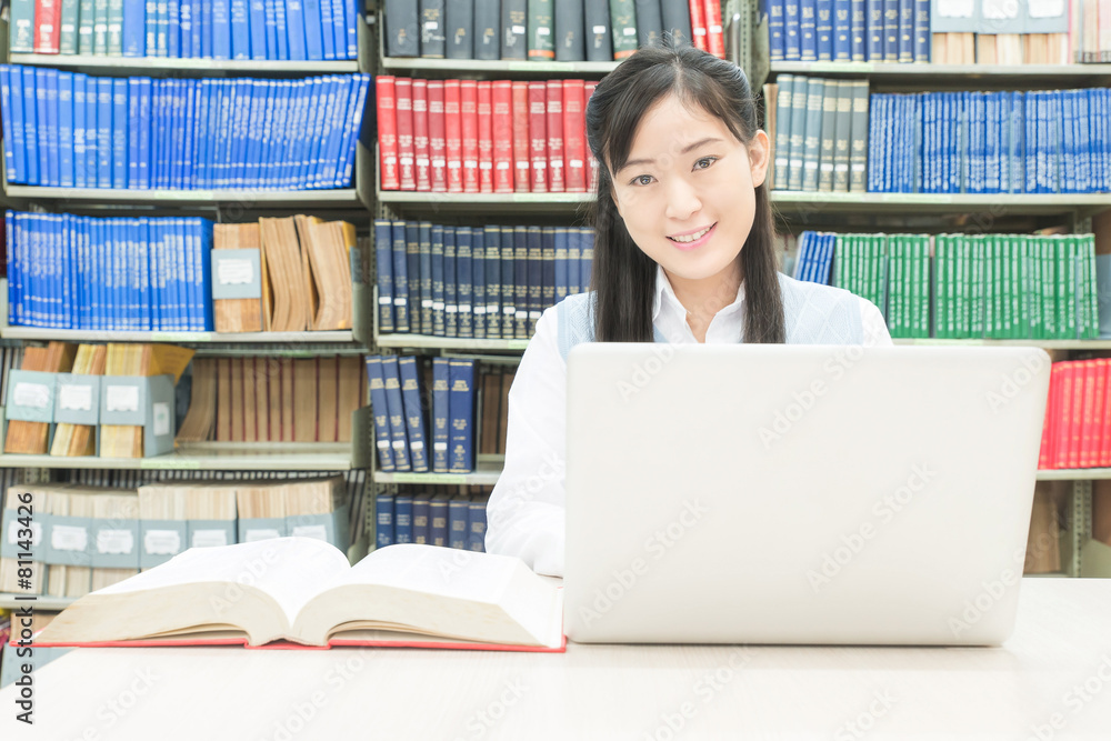 亚洲学生在大学图书馆使用笔记本电脑