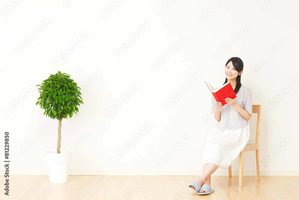 部屋で本を読む女性