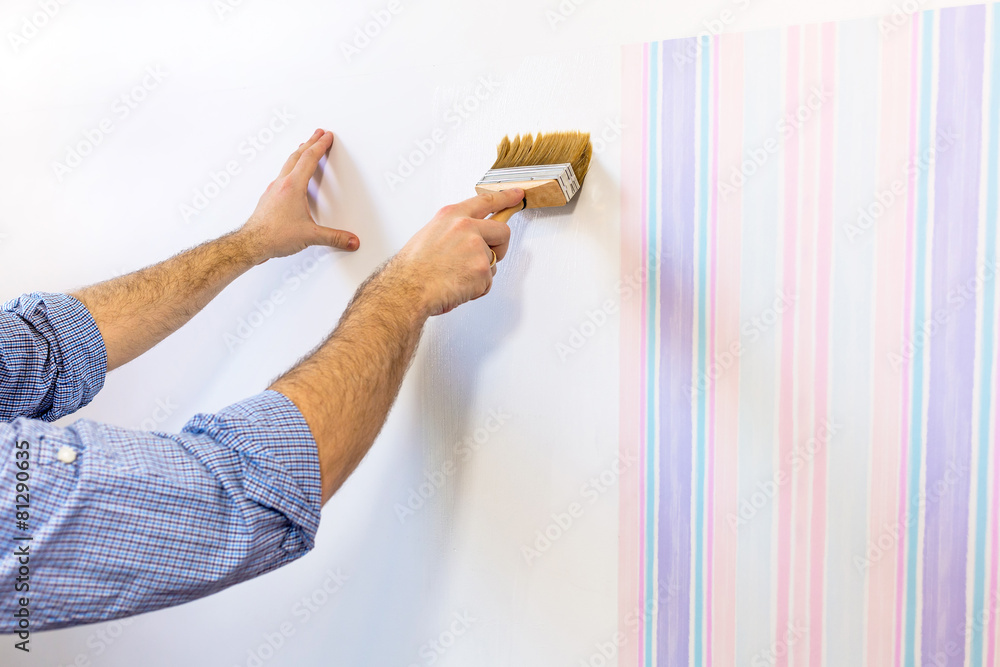 勤杂工用背景胶粉刷墙壁作为壁纸