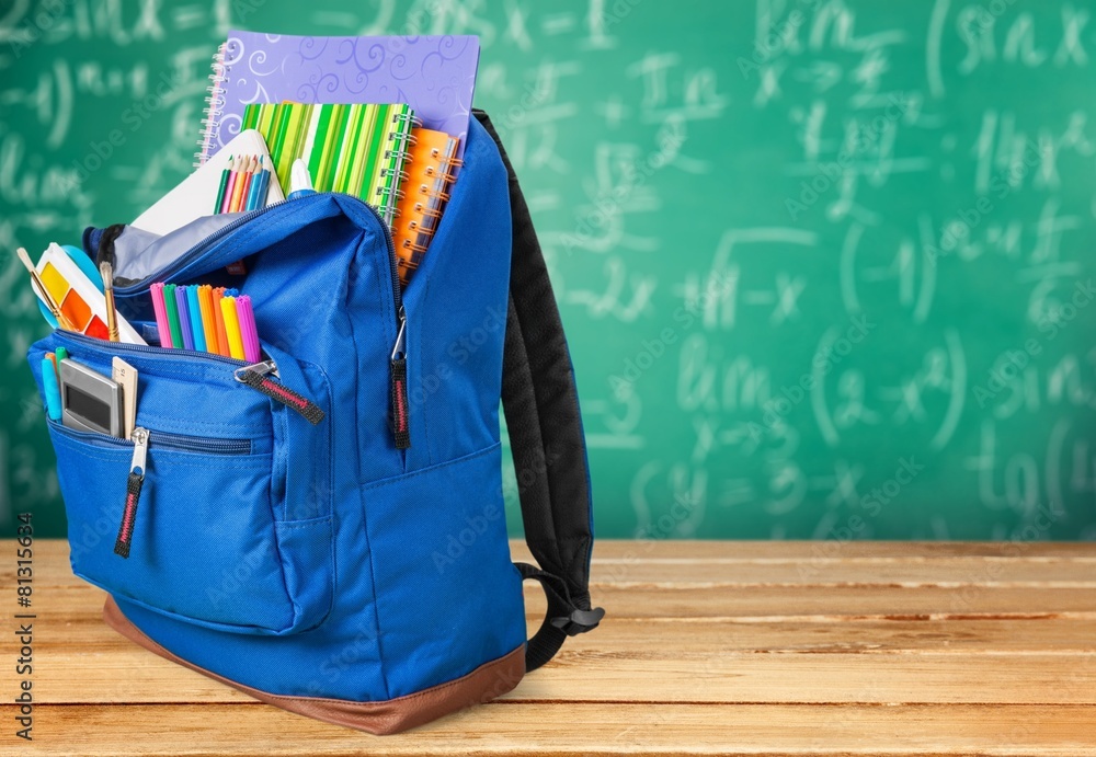 学校。装有学习用品的背包，包括笔记本、钢笔