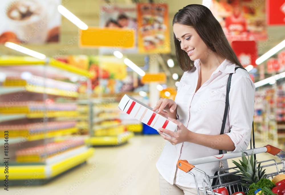 超市。女性在超市检查食品标签。