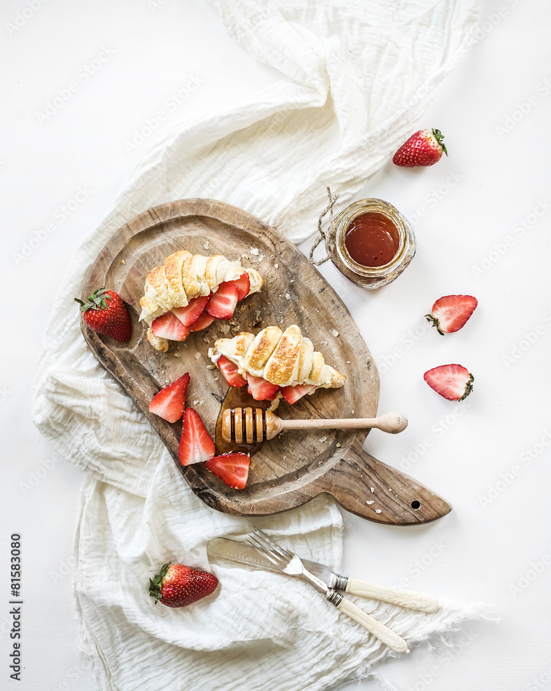 Freshly baked croissants with strawberries, mascarpone and honey
