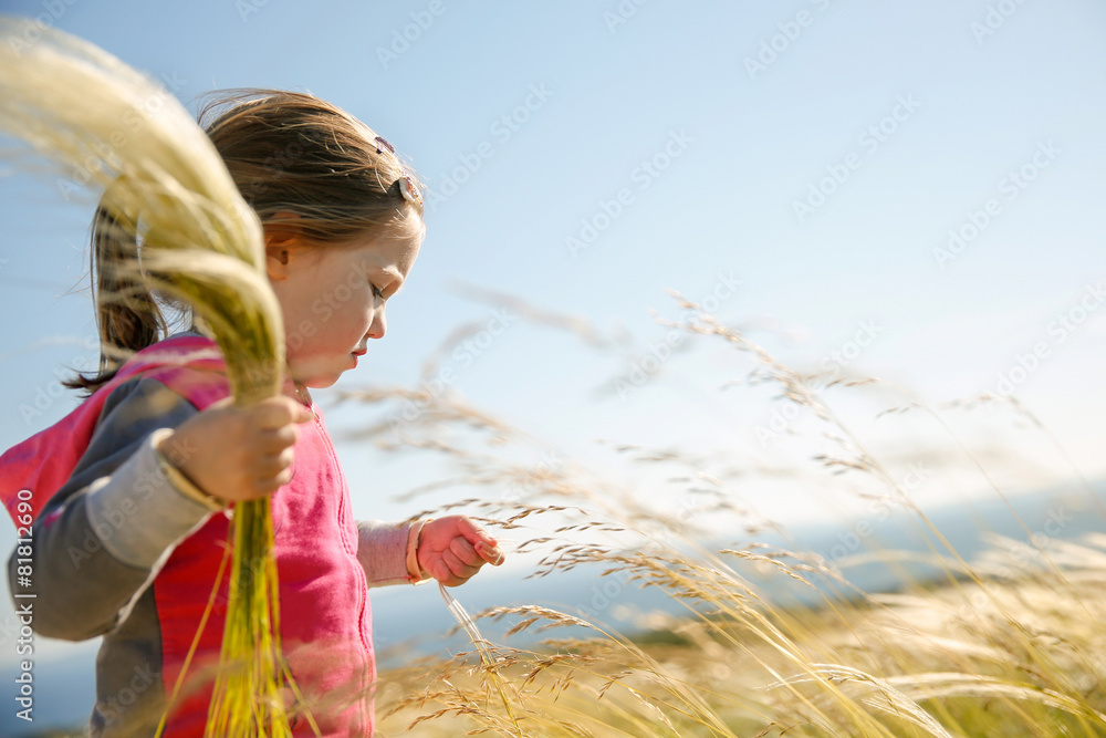 可爱的小女孩在吃草