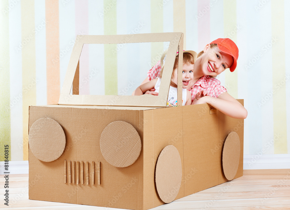 幸福的家庭母亲和小女儿乘坐由…制成的玩具车