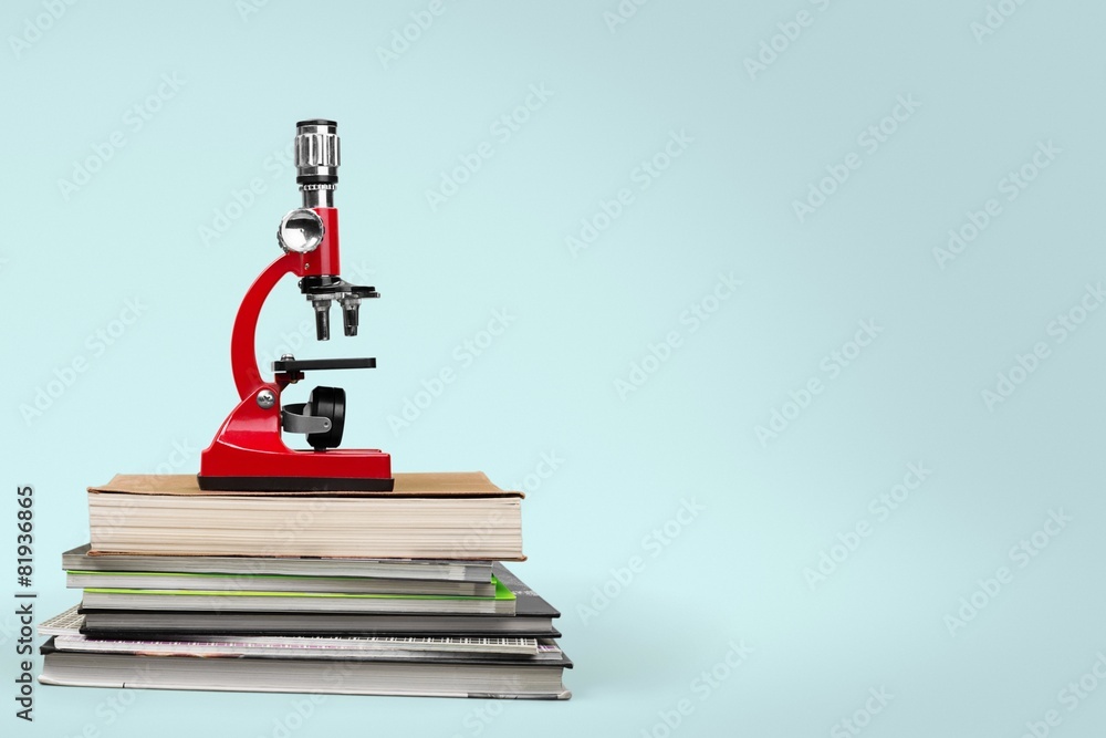 School. Color photo of a microscope on stack of books