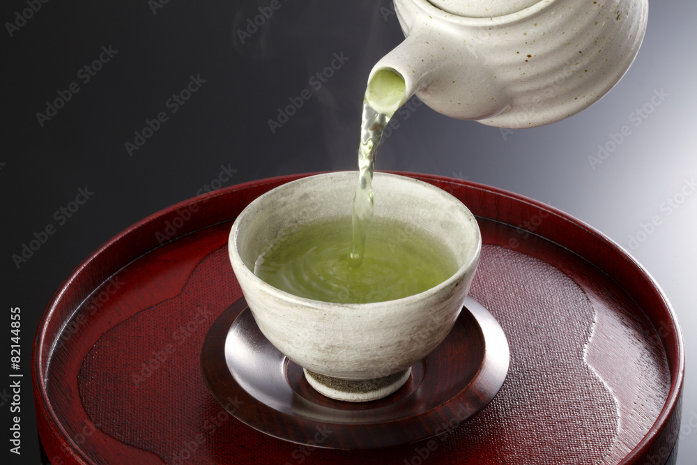 瓷杯和茶壶中的日本绿茶。