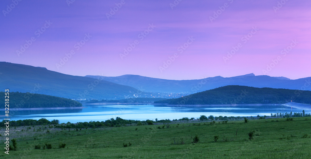 美丽的风景。夏天在山上日落。湖泊