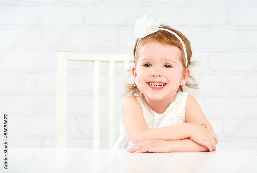 快乐有趣有趣的女孩在空的白色桌子上大笑