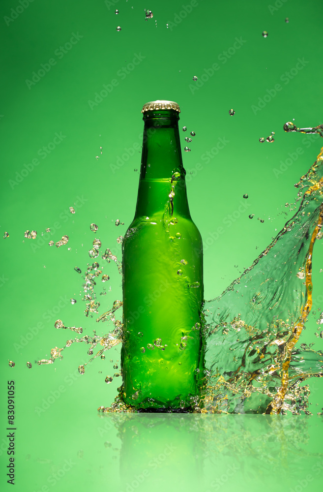 绿色背景上有飞溅物的啤酒瓶