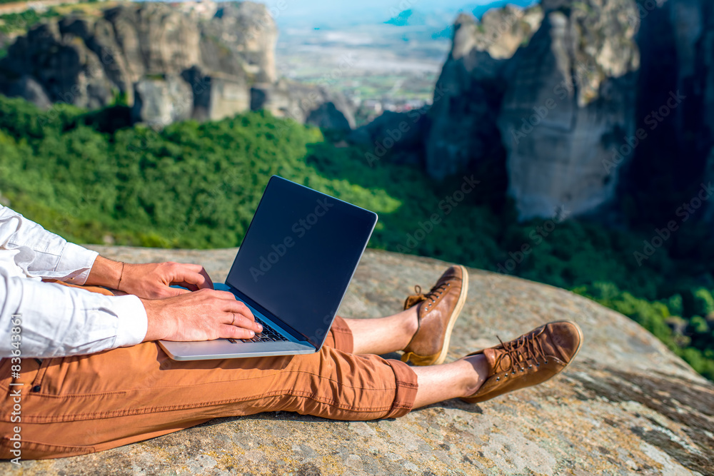 Man with laptop on the mountains
