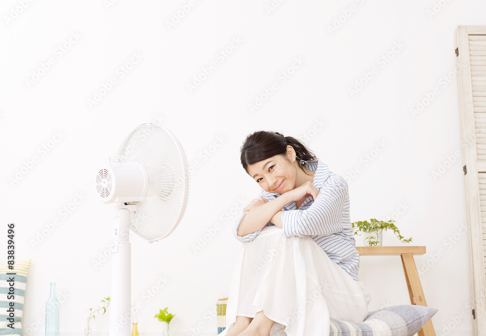 扇風機で涼む女性