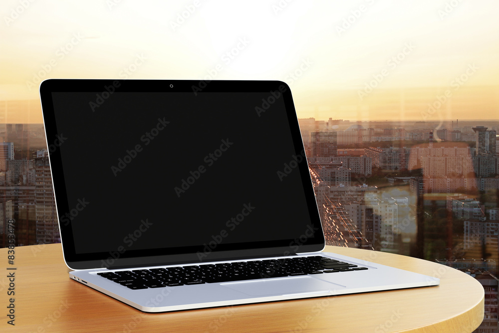 blank laptop on a table by the window