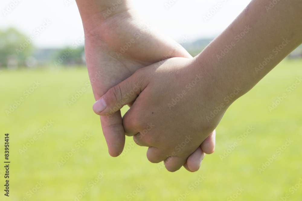 The hands of children holding hands in the park