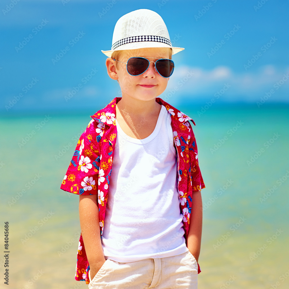 走在夏日沙滩上的可爱时尚男孩