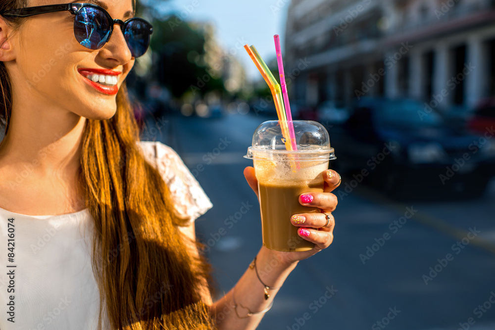 Woman walking on the street with take away coffee 
