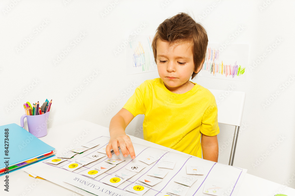 Boy plays in developing game pointing at calendar