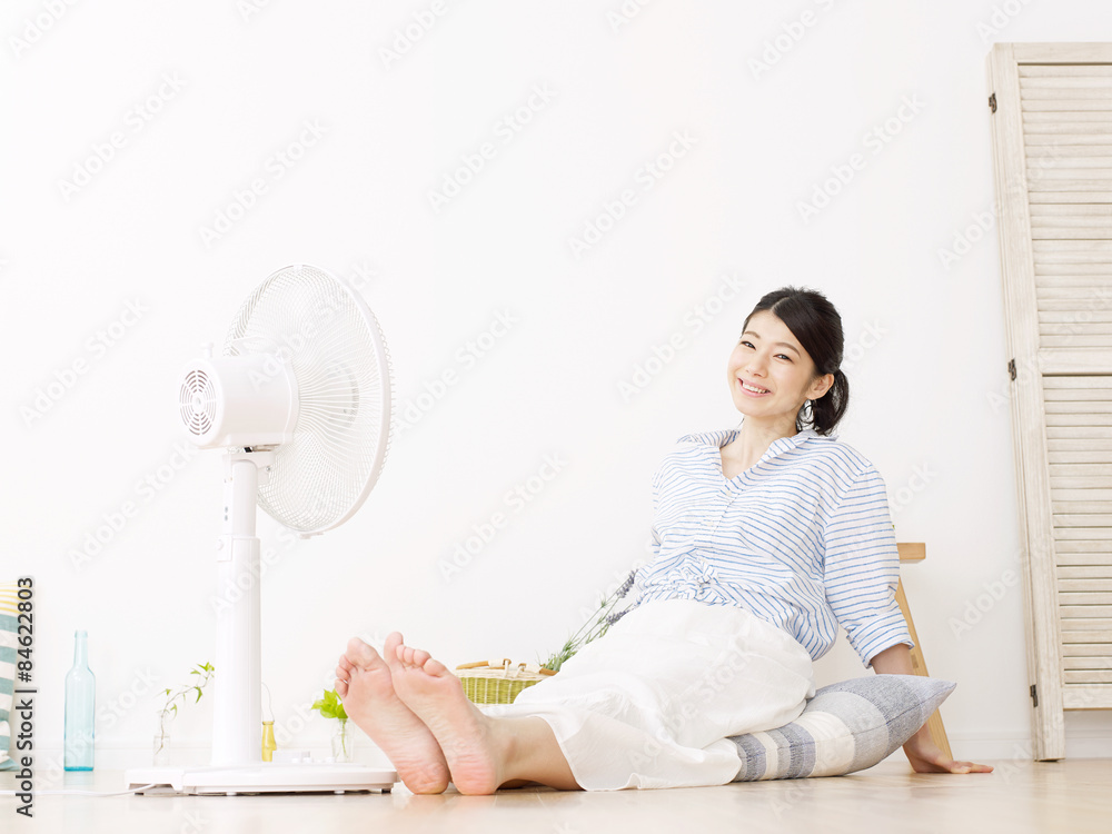 扇風機で涼む女性