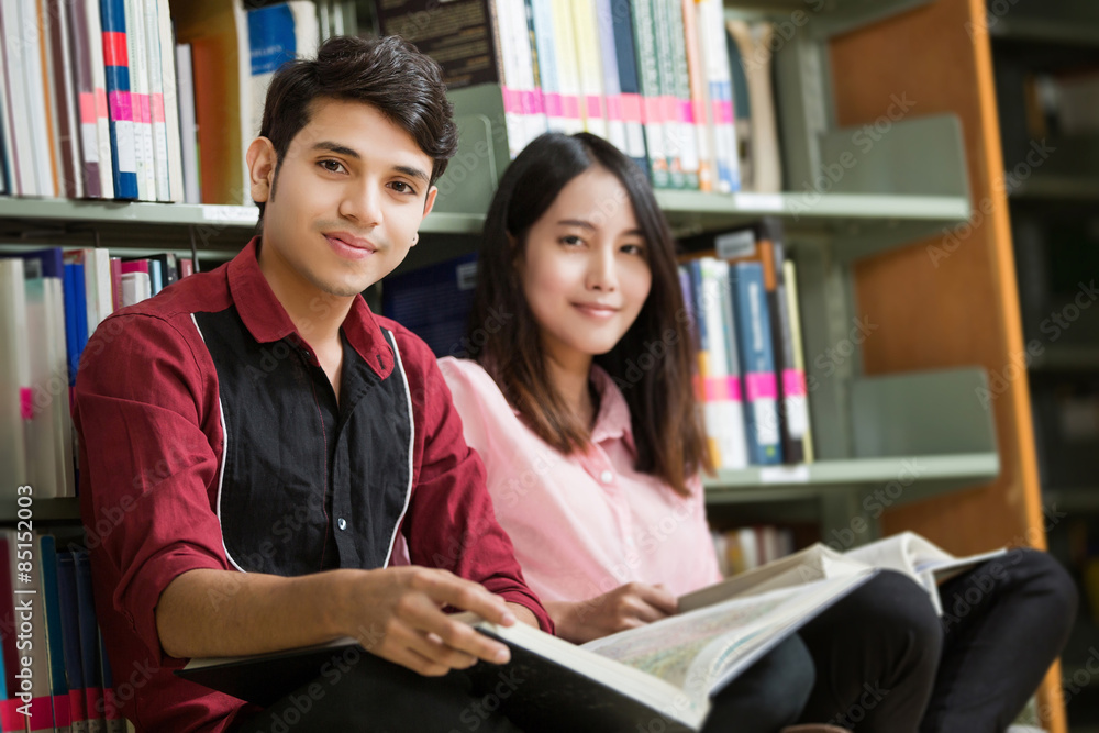 亚洲男女学生在图书馆阅读
