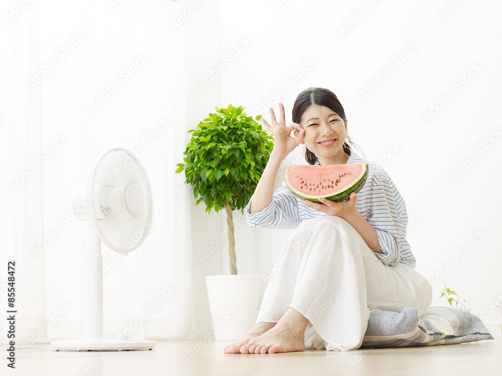 部屋で西瓜を食べる女性