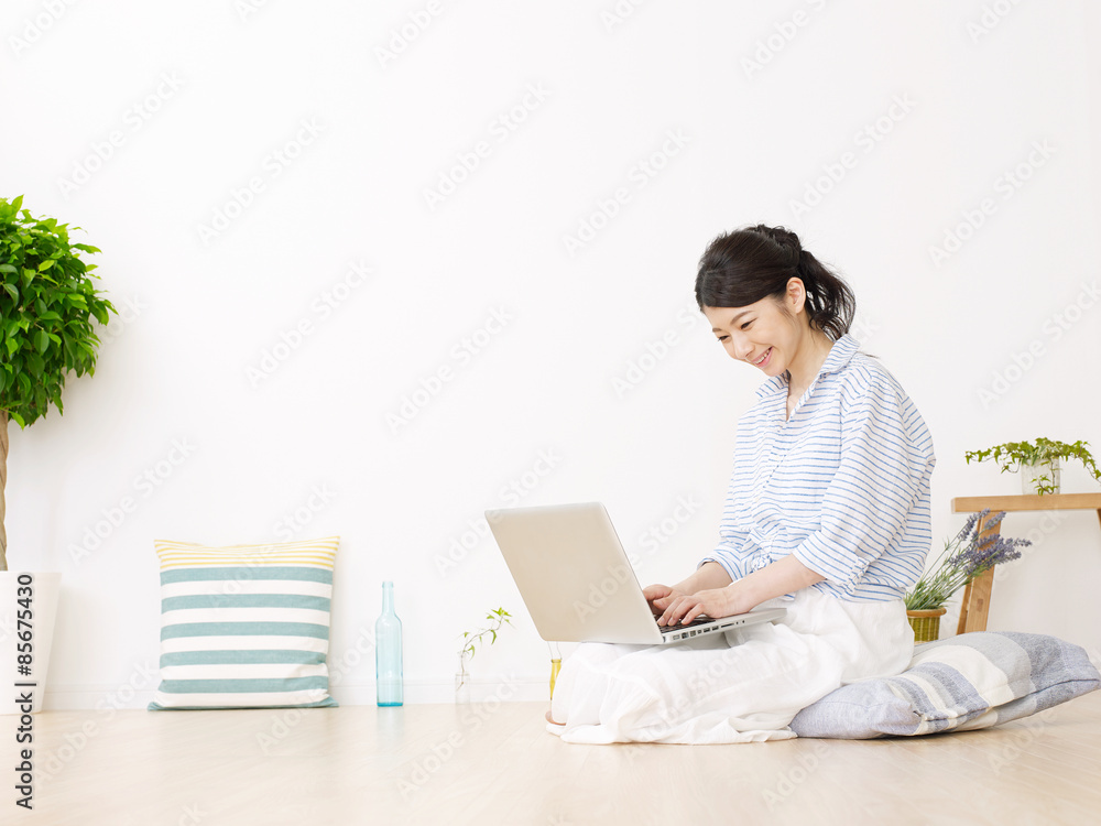 部屋でパソコンを使う女性